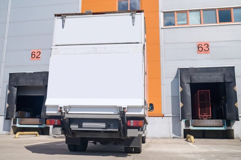 Camión de reparto en espera de carga junto a un almacén
