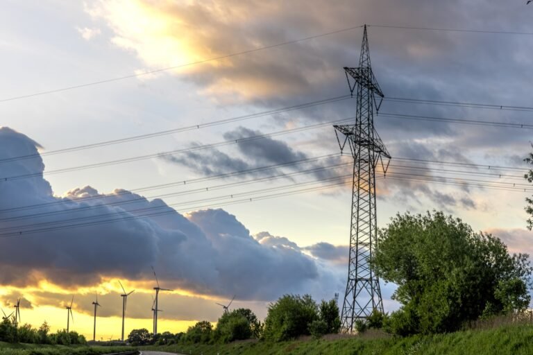 Torre metálica de transmisión eléctrica de alta tensión con sus líneas al atardecer