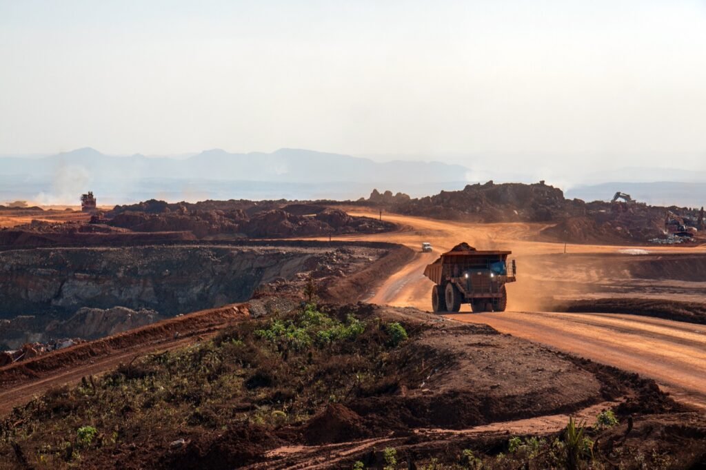 Camiones de acarreo transportan mineral de cobre en una mina a tajo abierto