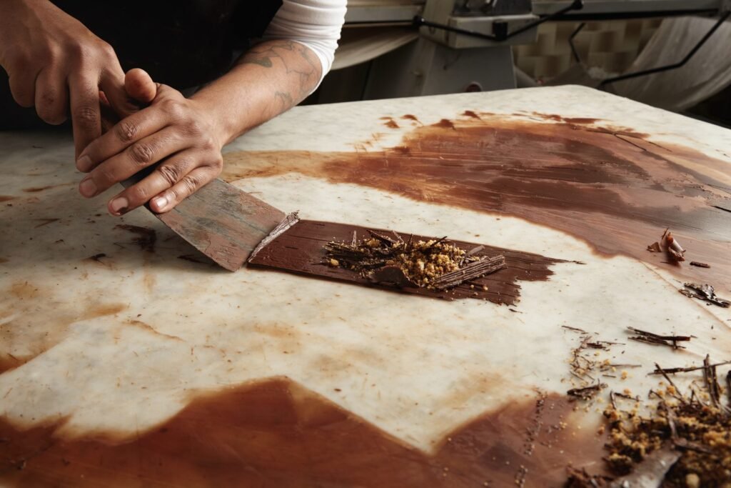 Chocolate atemperado sobre una mesa de mármol en un taller de chocolatería