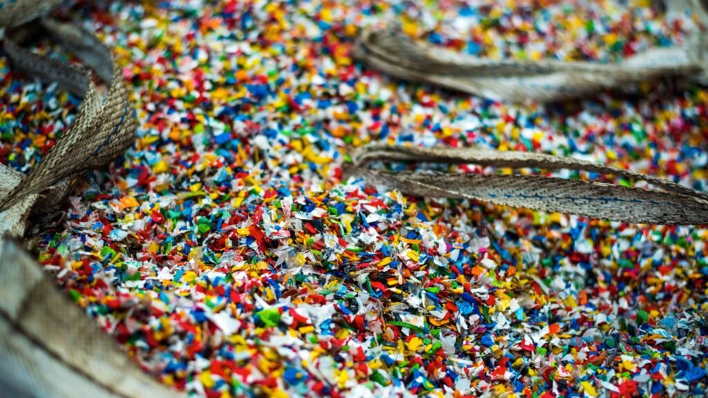 Saco de polietileno triturado de colores en una planta de reciclaje de plástico