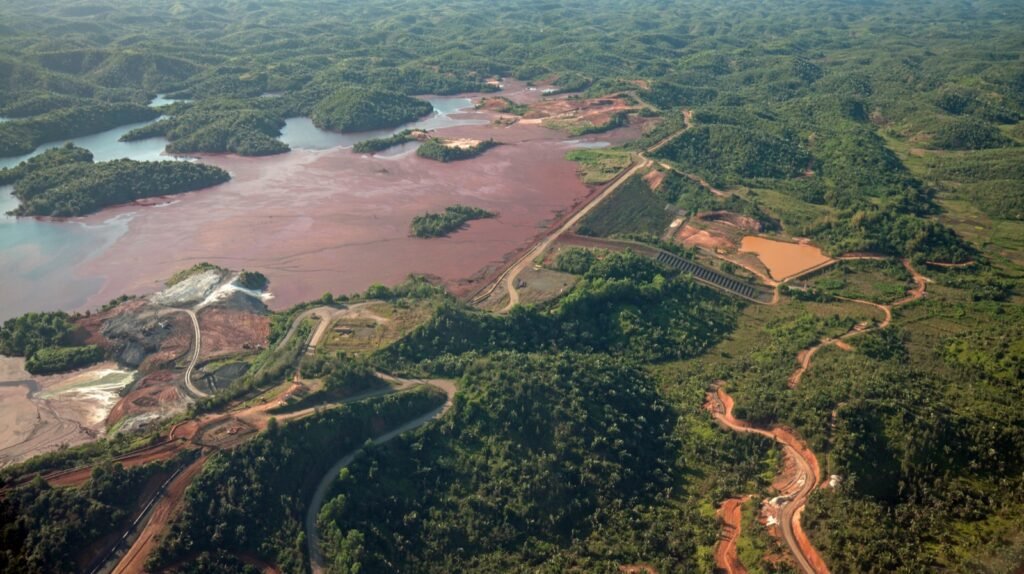 Vista aérea de un depósito de relaves mineros rodeado de vegetación