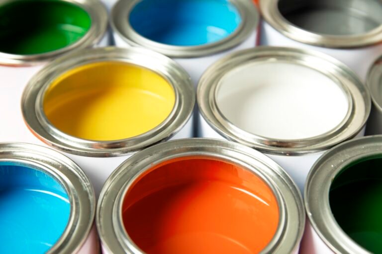 Latas de pintura abiertas de distintos colores vistas desde arriba